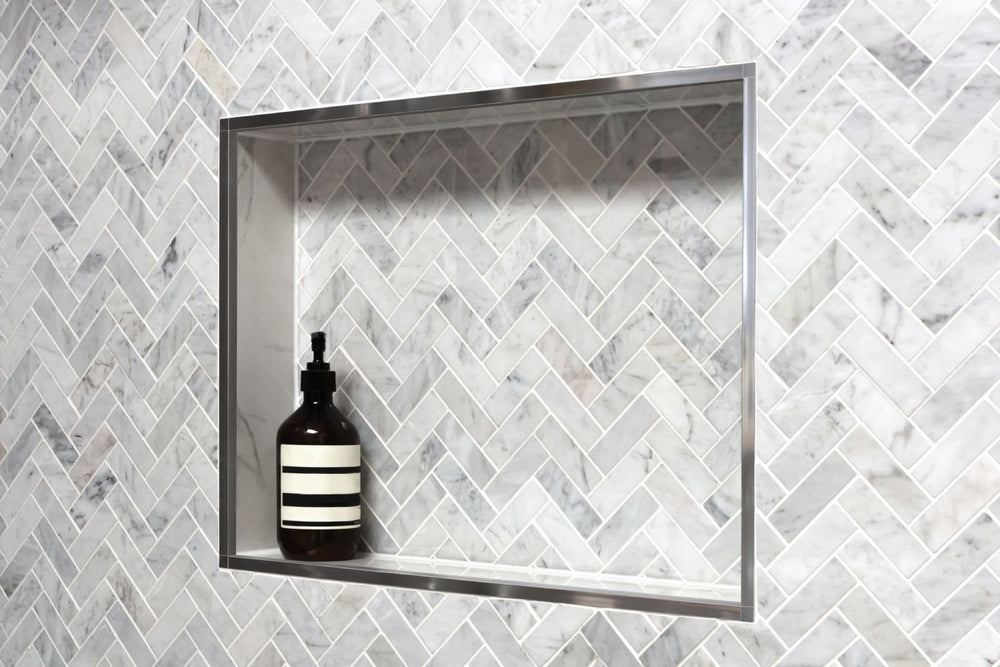 
                  
                    A medium show niche with a gray tile pattern holding a shampoo bottle.
                  
                