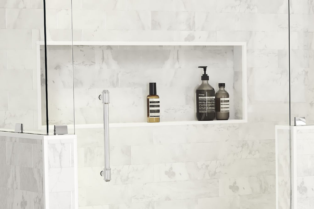 
                  
                     A standing shower with a large white marbled shower niche holding shampoo, conditioner and body wash bottles.
                  
                