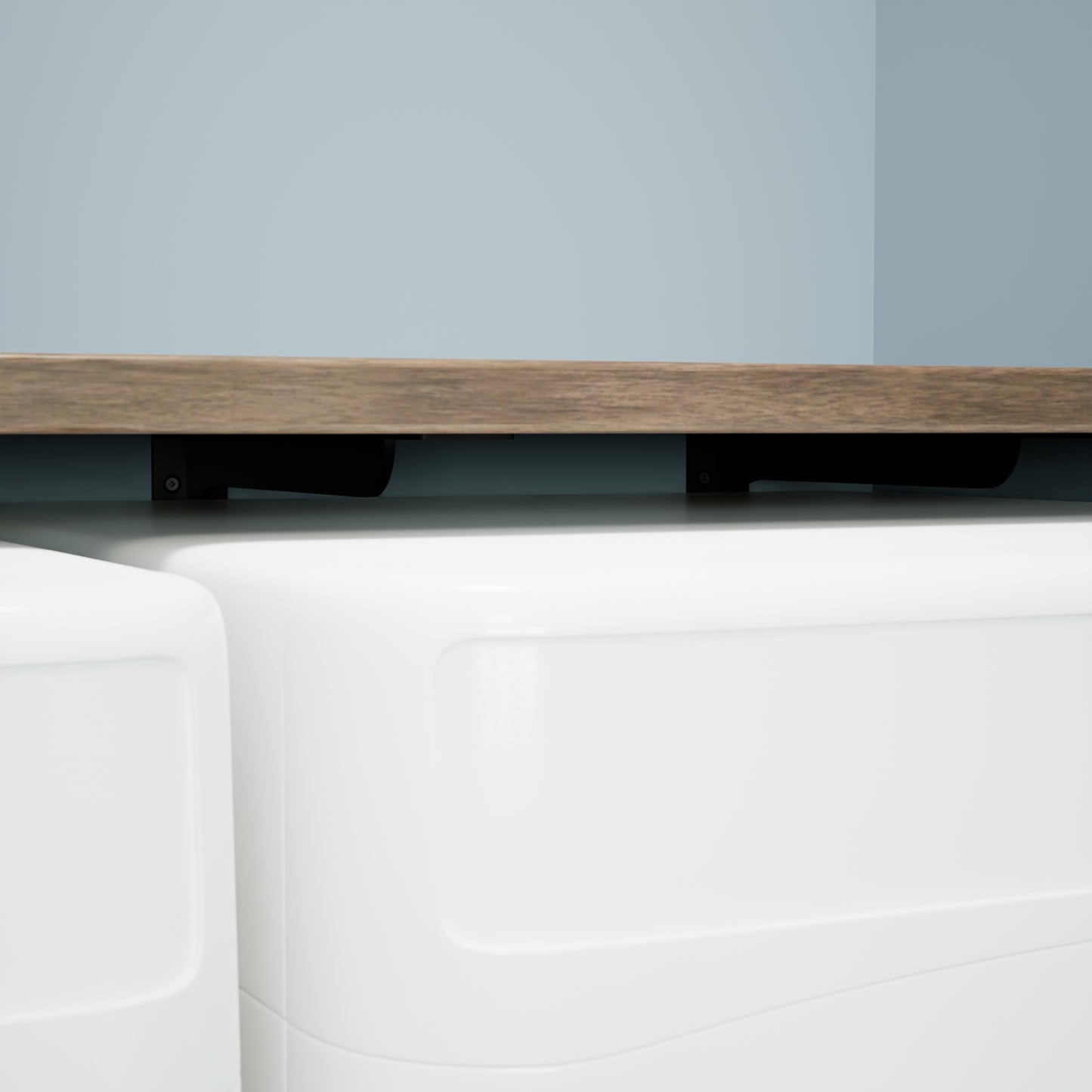 Close up view of the concealed Utility Shelf Bracket supporting a wood shelf over a washer and dryer.